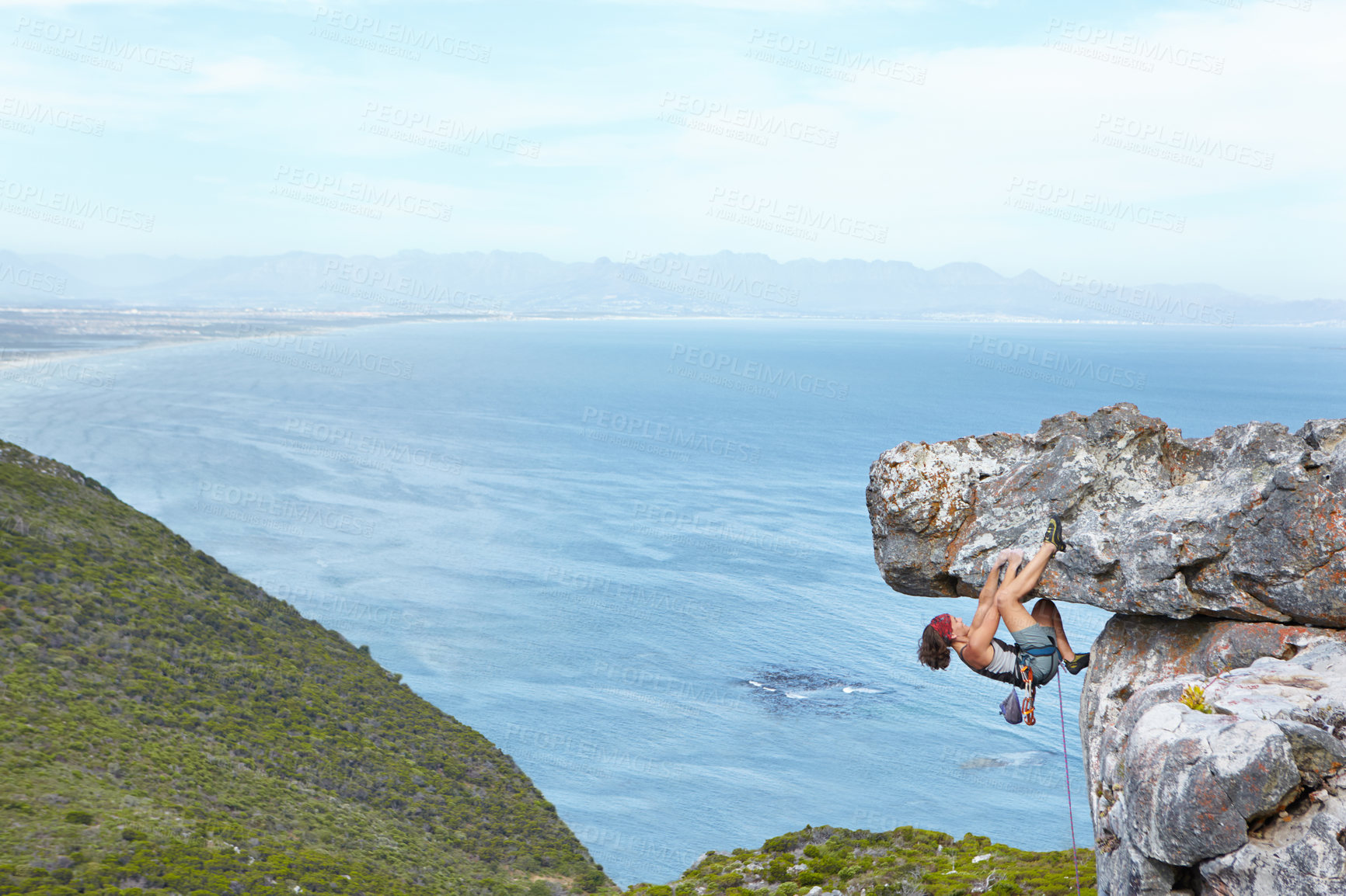 Buy stock photo A young woman climbing up the side of a mountain