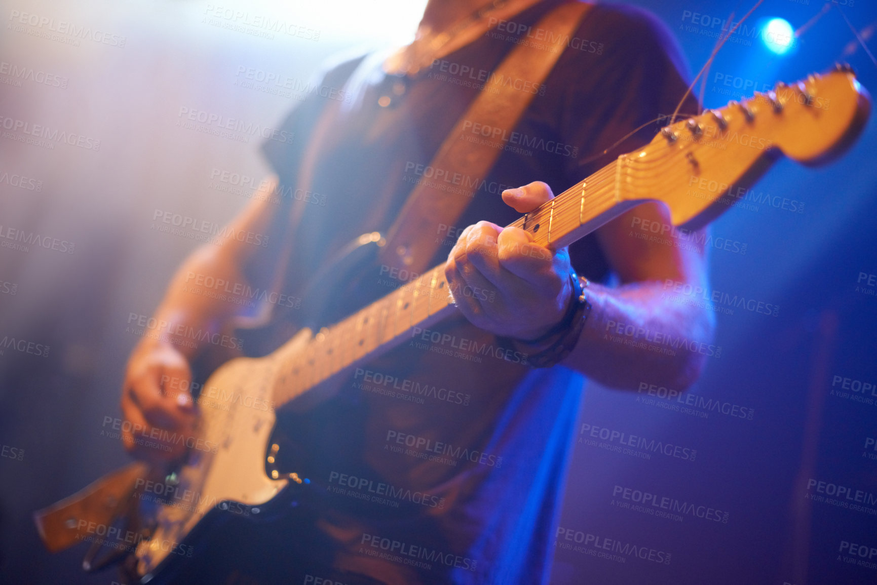 Buy stock photo A guitarist playing his heart out beneath the strobe lights 