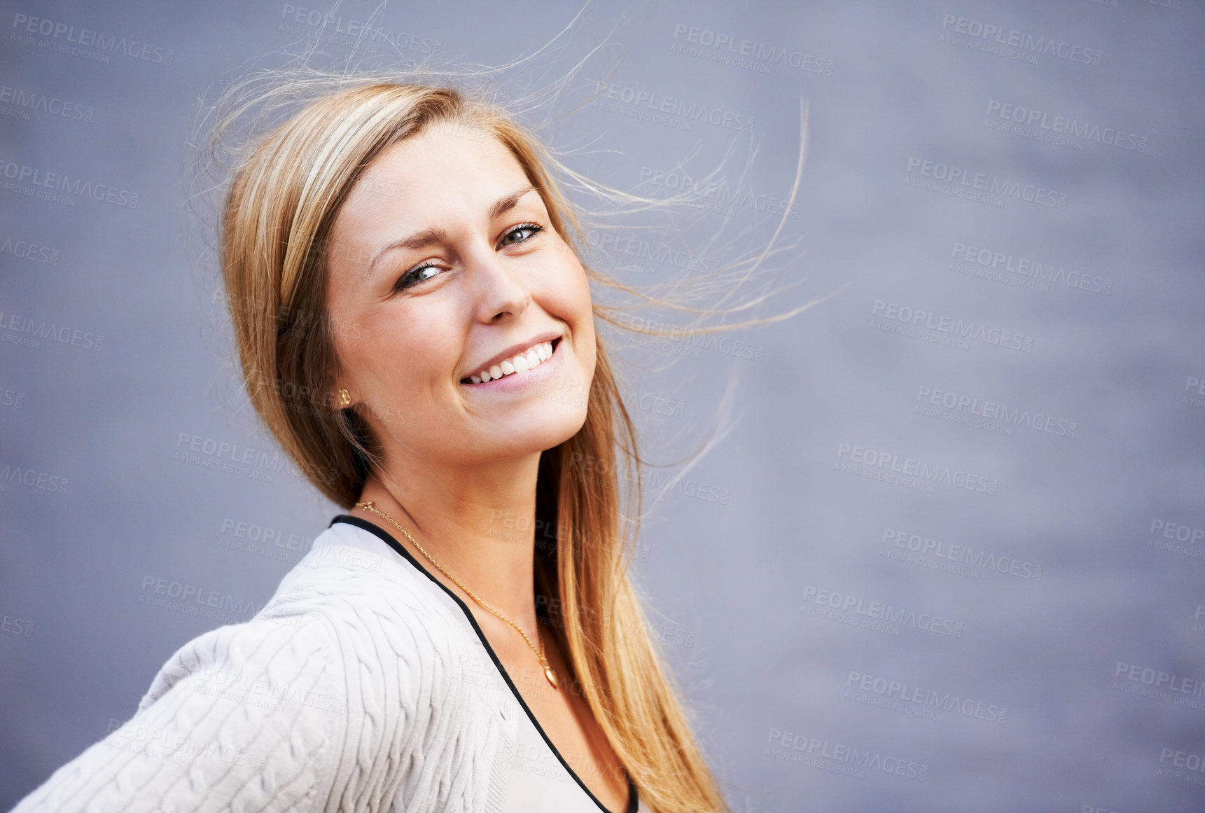 Buy stock photo Beauty, portrait and happy woman by wall in city, wind and outdoor alone. Face, fashion and smile of young person in urban town, stylish casual clothes or blonde girl with mockup space in Switzerland