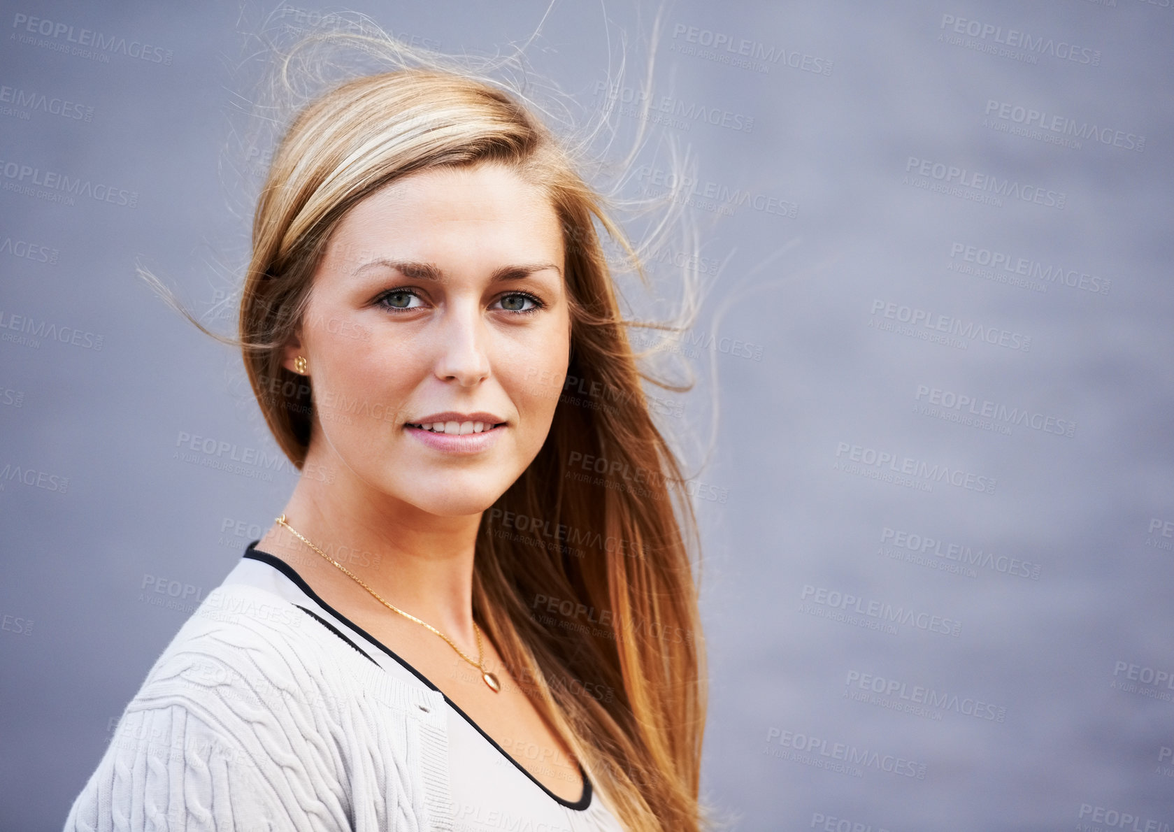 Buy stock photo Portrait of beautiful young woman posing outdoors against a gray background