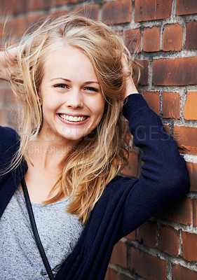 Buy stock photo Beauty, portrait and woman with hair by brick wall in city, smile or happy outdoor. Face, fashion and hairstyle of young person in casual clothes, facial expression and blonde girl in Switzerland