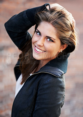 Buy stock photo Portrait, beauty and happy woman with hair by brick wall in city outdoor alone. Face, fashion and hairstyle of confident young person, casual clothes and facial expression of girl in Switzerland
