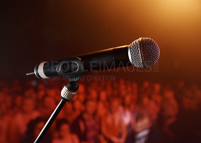 Buy stock photo A microphone standing on a stage with a crowd in the background