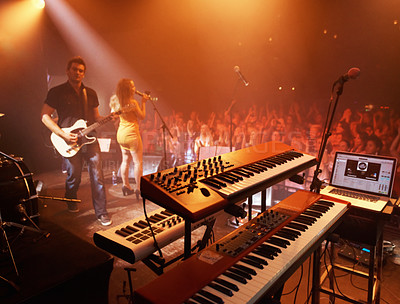 Buy stock photo Concert, band and keyboard at stage for performance with singer and musician on guitar. Music festival, crowd and people with talent playing for audience in theater at night with spotlight and energy