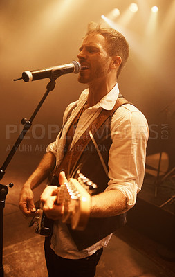 Buy stock photo Singer, music and guitar with man on stage for concert, performance and rock show. Event, spotlight and energy with male musician playing instrument at festival club for rave, disco and  celebration
