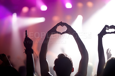 Buy stock photo Rearview of people in the audience at a music concert holding up their hands in a heart symbol