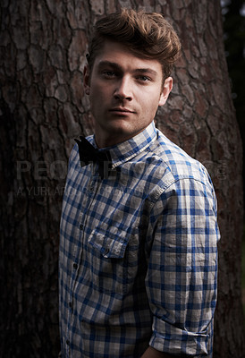 Buy stock photo Portrait of handsome young hipster standing in front of a tree