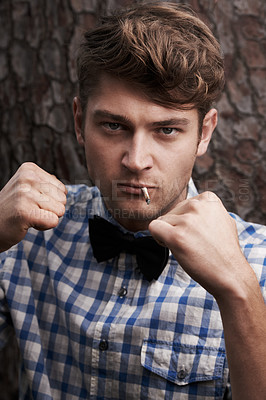 Buy stock photo Fight, smoking and portrait of man in outdoors for challenge, strong and fighting. Cigarette, hipster and anger with face of male person and hands up in nature for combat, cool and trendy style 