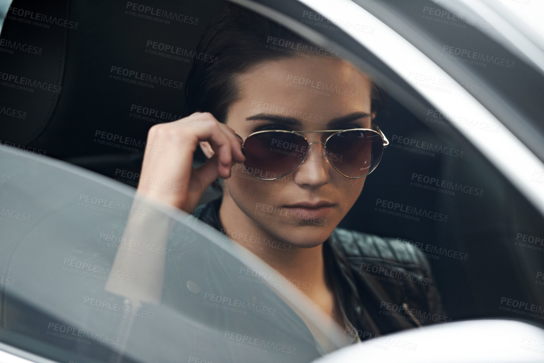 Buy stock photo Shot of an attractive young driver looking through the front windshield