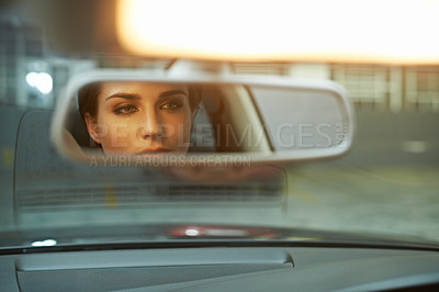 Buy stock photo A stylish woman checking her face in the rear view mirror