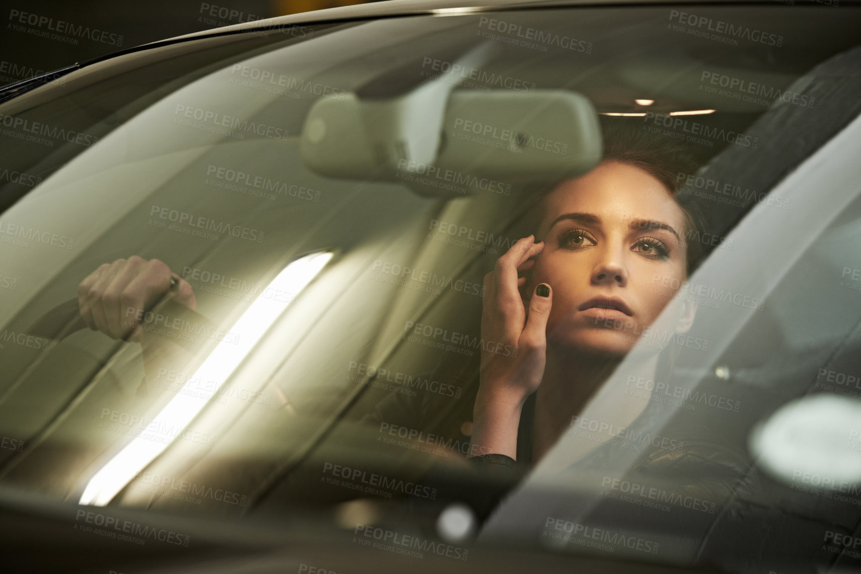 Buy stock photo Shot of an attractive young driver looking through the front windshield