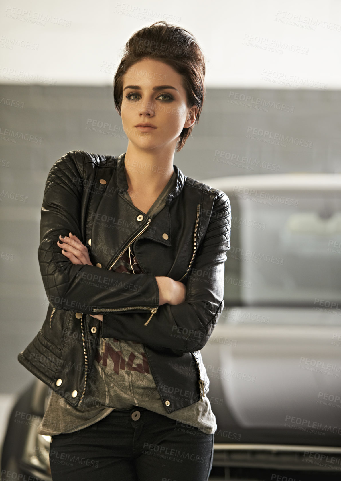 Buy stock photo A young woman standing by her car with her arms folded