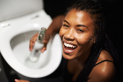 Buy stock photo Black woman, face and drinking alcohol by toilet in party event, birthday celebration or nightclub social gathering. Portrait, smile or happy drunk person with beer bottle in music festival bathroom