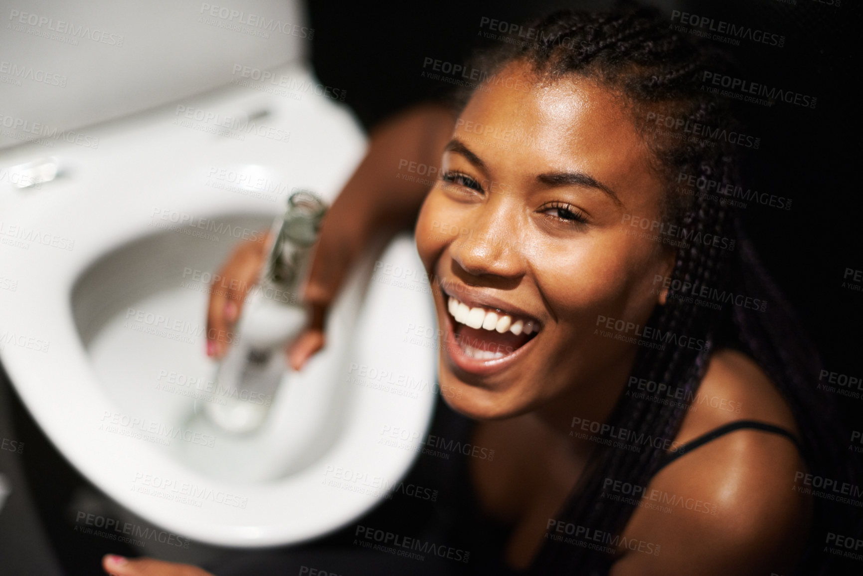Buy stock photo Black woman, face and drinking alcohol by toilet in party event, birthday celebration or nightclub social gathering. Portrait, smile or happy drunk person with beer bottle in music festival bathroom