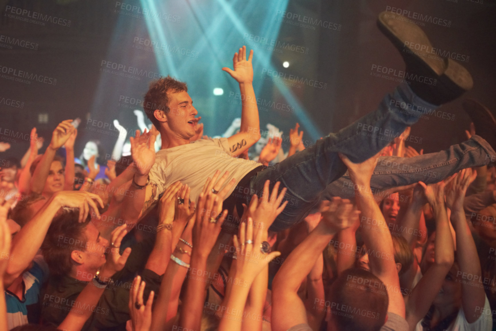 Buy stock photo Music, party and crowd surfing with man at concert for rock, celebration and festival. Energy, light and dance with audience listening to live band show performance at disco, summer break and dj