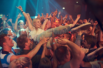 Buy stock photo Music, party and concert with a woman crowd surfing during a show or event in a stadium for performance. Festival, celebration and audience with a female enjoying live entertainment in an arena