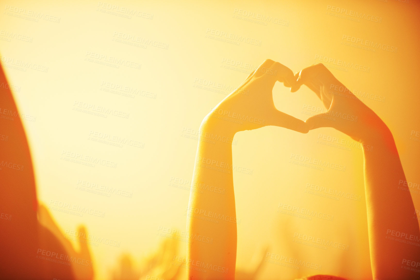 Buy stock photo Shot of a spectator making a heart shape with her hands at a rock concert