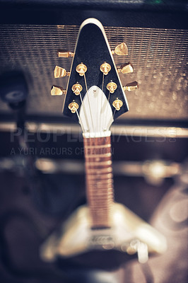 Buy stock photo High angle view of a guitar leaning on an amp.