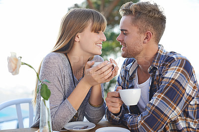 Buy stock photo A young couple enjoying breakfast outside