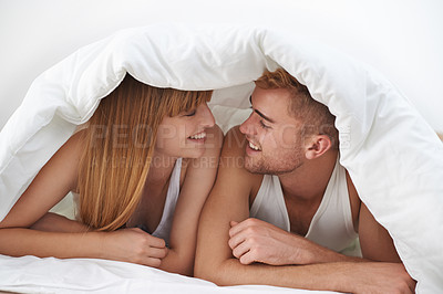 Buy stock photo Happy couple, romantic and moment in bed, together and excited for marriage, happy and relax. Partners, speaking and smile with love, home and lying under duvet for bonding in morning at apartment