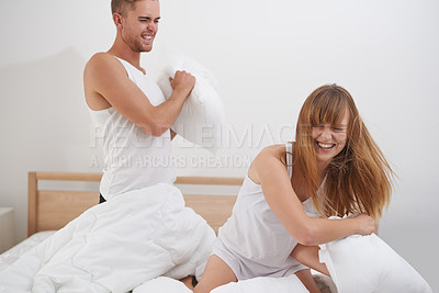 Buy stock photo Couple, pillow fight and funny in bed with happiness and together in relationship. Lovers, lifestyle and silly for love, cheerful and comic with laughter for joy and smile on faces at home 