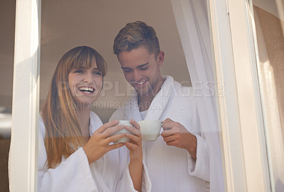 Buy stock photo Couple, relaxing and drinking coffee by window and love on weekend, romance and hot tea at home. Happy people, bonding and laughing for humor, commitment and loyalty to marriage or relationship