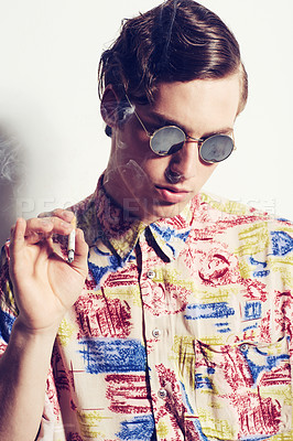 Buy stock photo Shot of a stylish man posing with a cigarette bud