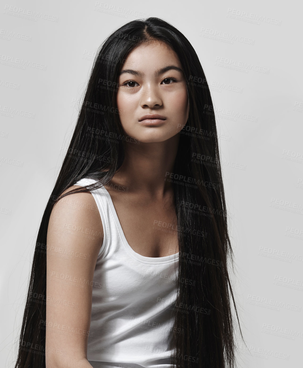 Buy stock photo Studio shot of a beautiful young woman posing against a gray background