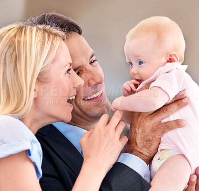 Buy stock photo Young mother and father giggling with their baby