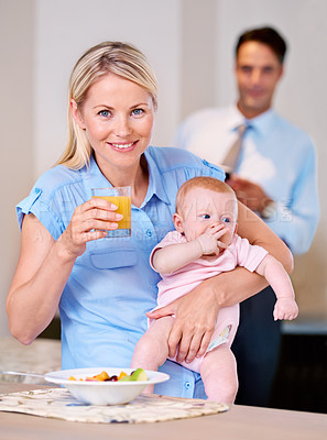 Buy stock photo Portrait, mother and baby with juice and breakfast in the morning with businessman leaving for work. Woman, food and eating fruit with little child or kid for healthy diet and father in background