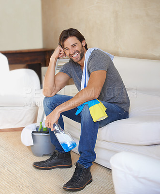 Buy stock photo Shot of a young man taking a break from cleaning the house