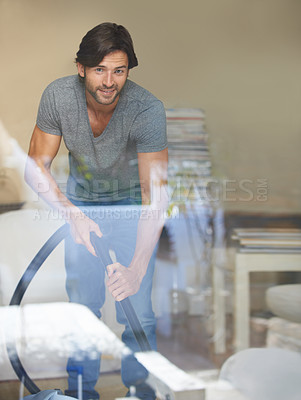 Buy stock photo Shot of a young man cleaning his house