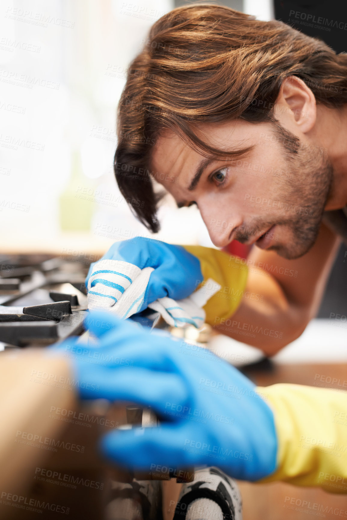 Buy stock photo Man, kitchen and serious in cleaning a countertop with cloth, spring clean and polishing for hygiene at home. Stove, responsibility and routine to remove dirty stains, germs with water and soap 