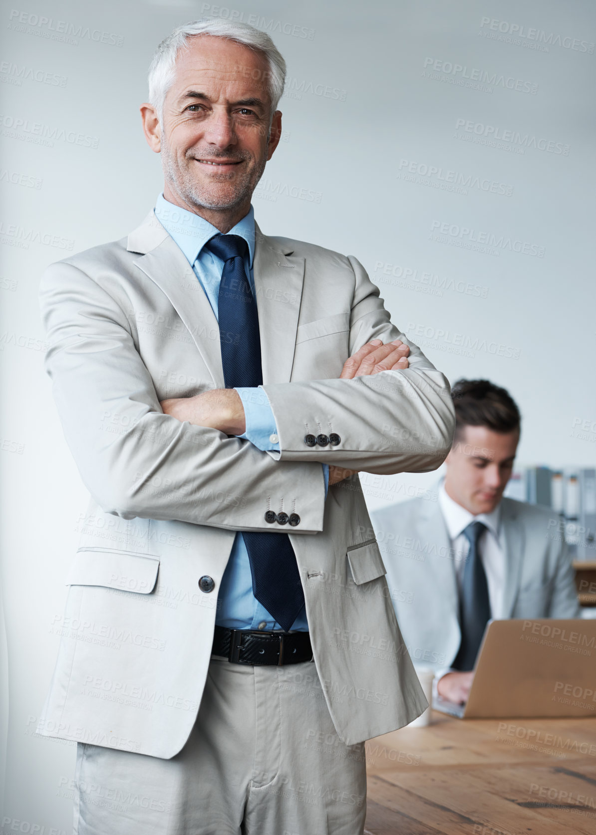 Buy stock photo Senior businessman, portrait and confidence in leadership, agency and pride for mentoring in office. Male person, arms crossed and smile for support in management, advisor and laptop for planning