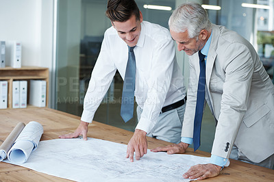 Buy stock photo Two corporate architects going over the plans of a building together