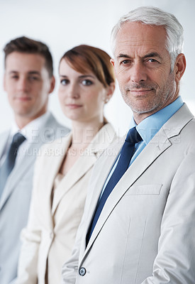 Buy stock photo Portrait of three corporate business people , standing in a row and inside of the boardroom . Smiling friendly group of three business partners of different age private company staff posing  