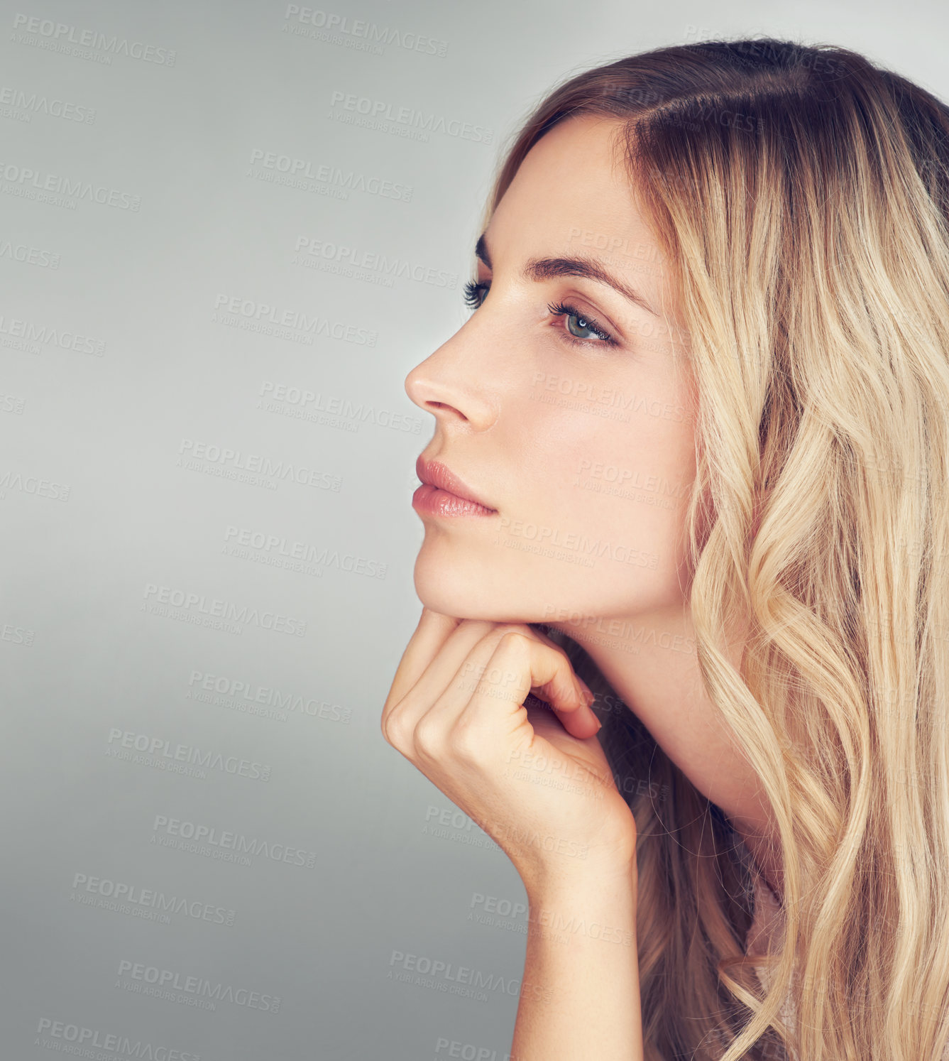 Buy stock photo Side view of an attractive young woman looking thoughtful in studio