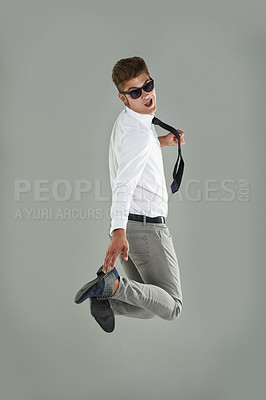 Buy stock photo Businessman, jump and celebration for win in studio, professional and energy for success or victory. Male person, excited and sunglasses on gray background, playful and satisfaction for announcement