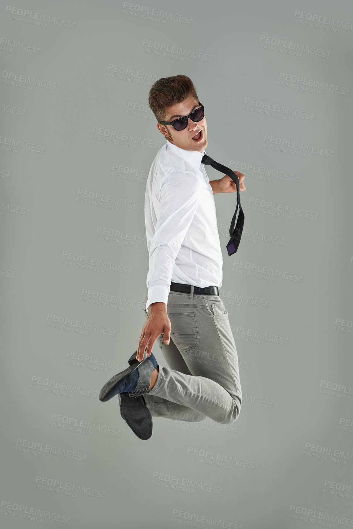 Buy stock photo Businessman, jump and celebration for win in studio, professional and energy for success or victory. Male person, excited and sunglasses on gray background, playful and satisfaction for announcement