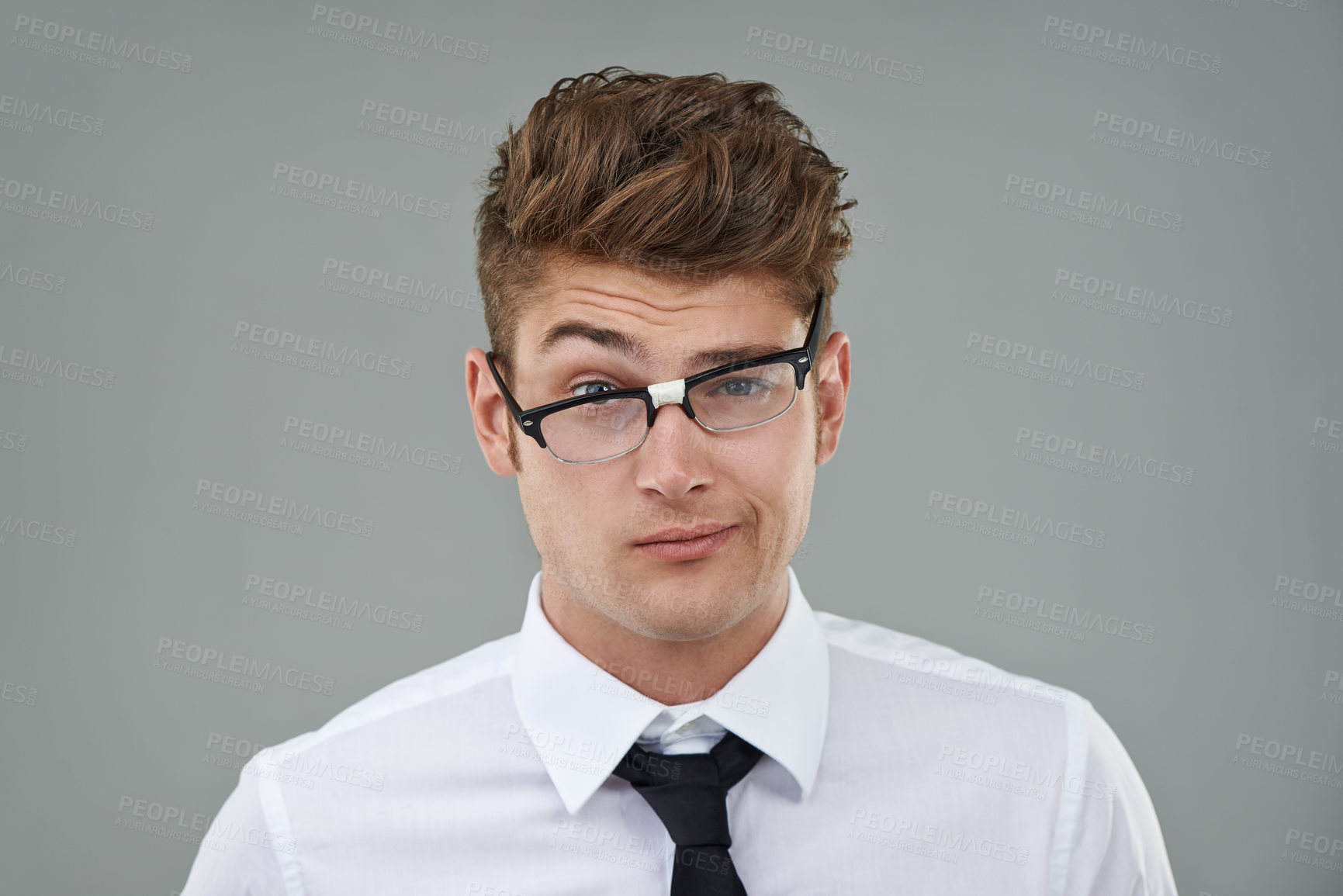 Buy stock photo Businessman, glasses and funny portrait in studio for optical healthcare, comedy and humor on gray backdrop. Male person, eyewear and joking with frame choice, optometry and lens for vision support