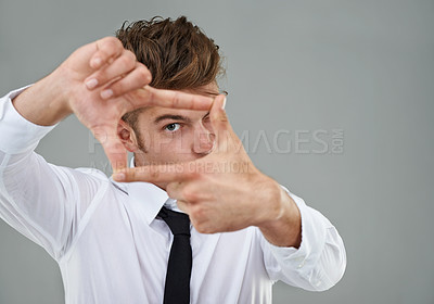 Buy stock photo A young man wearing a shirt and tie framing his eye between his fingers