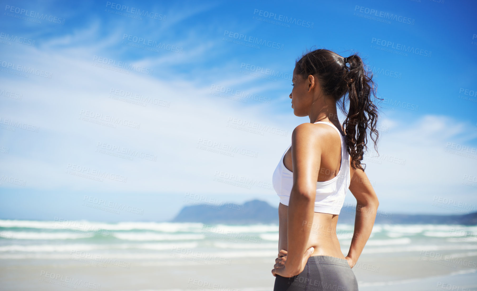 Buy stock photo A young jogger standing on the beach