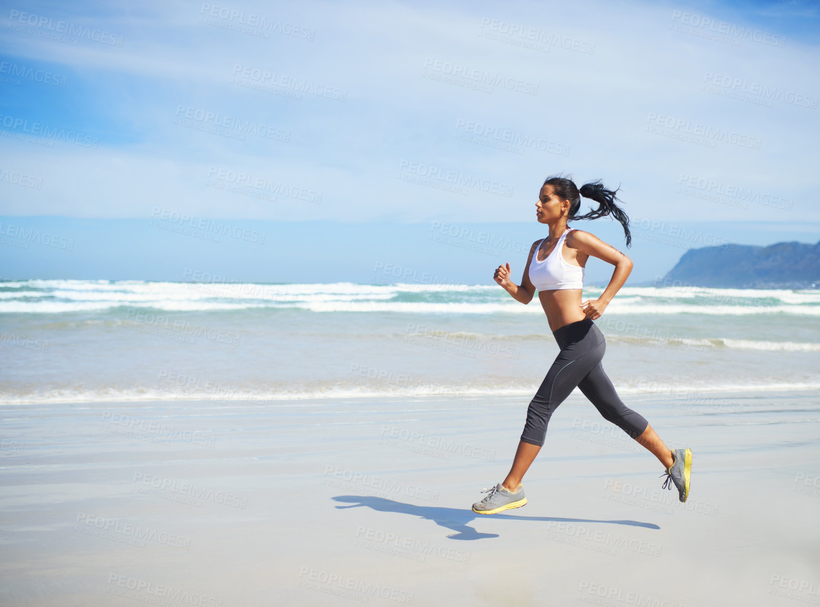 Buy stock photo Full length shot of a young woman running along the seashore