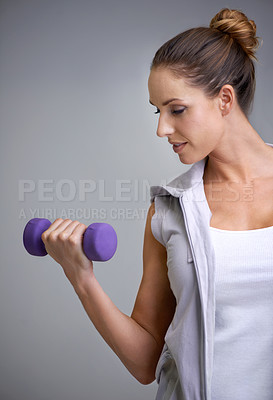 Buy stock photo A young woman working out with weights