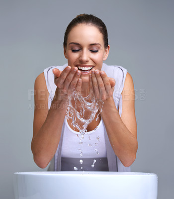 Buy stock photo An attractive young woman washing her face