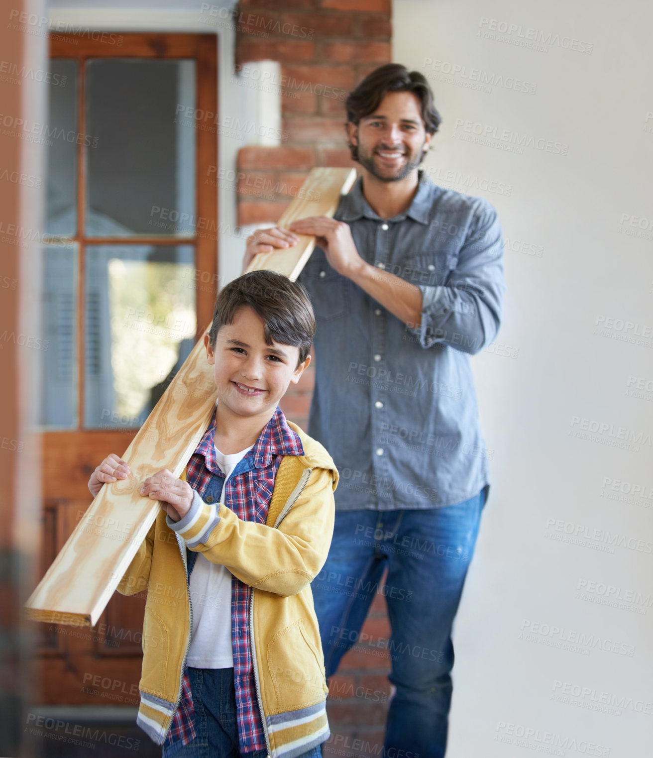 Buy stock photo A young boy helping his father with the home improvement