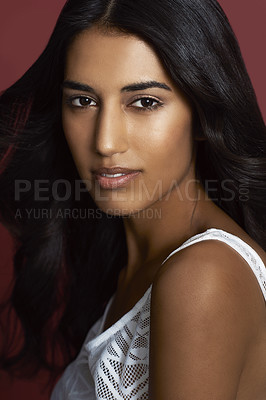 Buy stock photo Beauty, makeup and portrait of a woman in a studio with a natural, glamour and face routine. Serious, beautiful and young female model from India with cosmetology facial isolated by maroon background