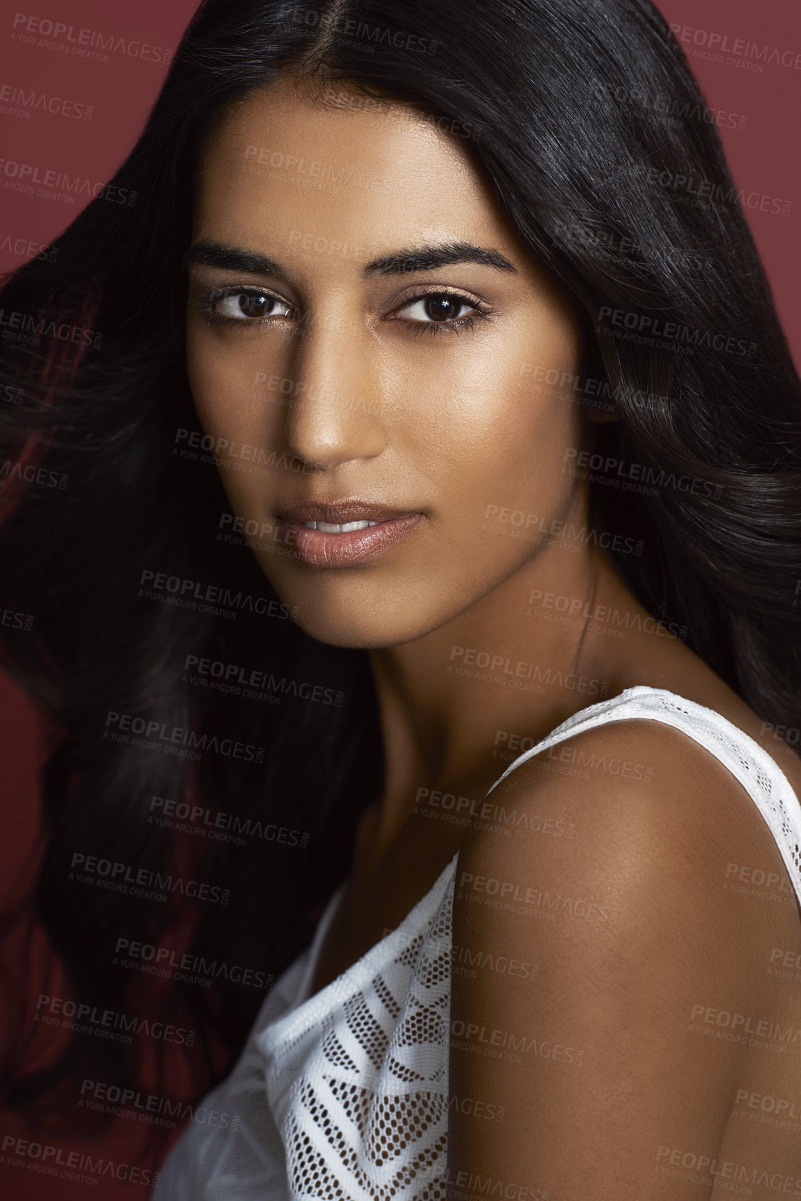 Buy stock photo Beauty, makeup and portrait of a woman in a studio with a natural, glamour and face routine. Serious, beautiful and young female model from India with cosmetology facial isolated by maroon background
