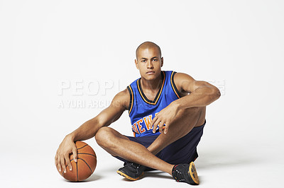 Buy stock photo Portrait, basketball player and man at white background, isolated and in studio for sports competition. Serious guy, male athlete and sitting on floor with ball, mockup space or ready for performance