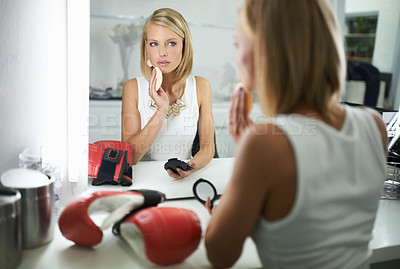 Buy stock photo Woman, wipe and boxing gloves by mirror, makeup and stylish outfit in dressing room. Female person, blush and eyeshadow for sport match, reflection and fashion to prepare for post interview
